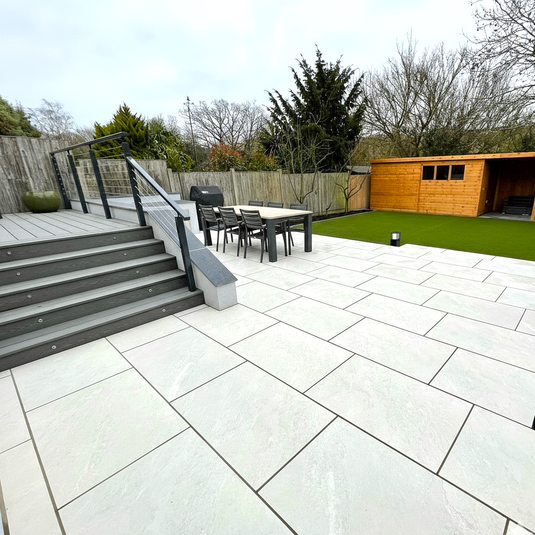 Backyard with patio, outdoor furniture, and wooden shed.